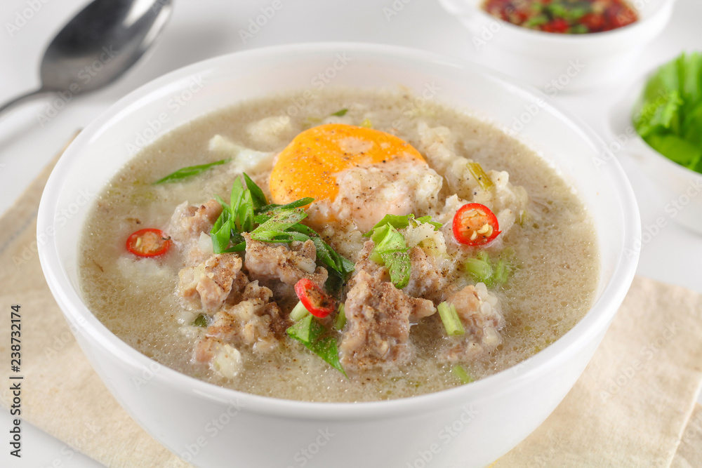 Congee with minced pork and boiled egg in bowl Congee with minced pork and boiled egg in bowl