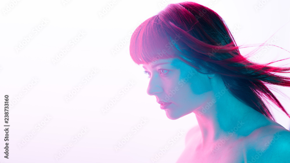 Beauty portrait of ginger caucasian woman with blue eyes on fuchsia and blue light and white background