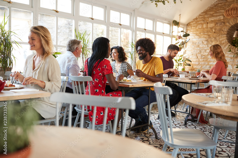 Customers eating at a busy restaurant in the day time Customers eating at a busy restaurant in the day time