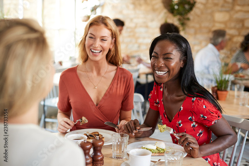 Young female friends smiling at brunch in a cafe, close up photo