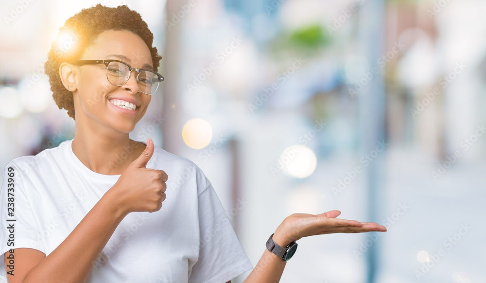 Beautiful young african american woman wearing glasses over isolated background Showing palm hand and doing ok gesture with thumbs up, smiling happy and cheerful Beautiful young african american woman wearing glasses over isolated background Showing palm hand and doing ok gesture with thumbs up, smiling happy and cheerful