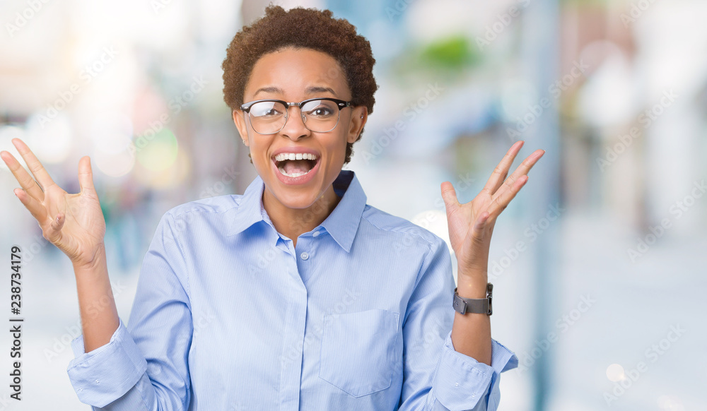 Young beautiful african american business woman over isolated background celebrating crazy and amazed for success with arms raised and open eyes screaming excited. Winner concept