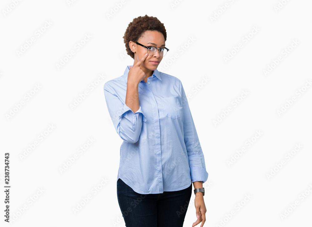 Young beautiful african american business woman over isolated background Pointing to the eye watching you gesture, suspicious expression Young beautiful african american business woman over isolated background Pointing to the eye watching you gesture, suspicious expression