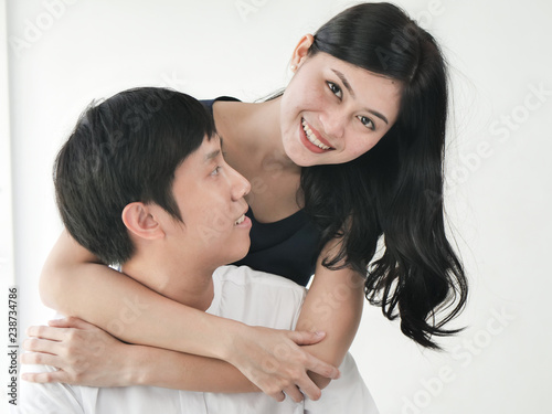 Romantic Asian couple hug and kissing near window at home, lifestyle concept.