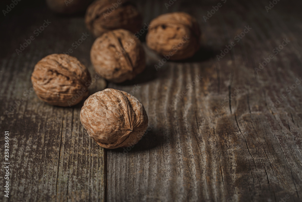 close up view of walnuts on wooden backdrop close up view of walnuts on wooden backdrop