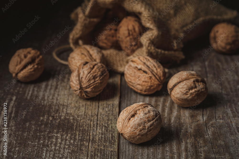 close up view of walnuts in sack on wooden background close up view of walnuts in sack on wooden background