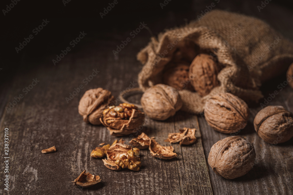 close up view of walnuts in sack on wooden background close up view of walnuts in sack on wooden background