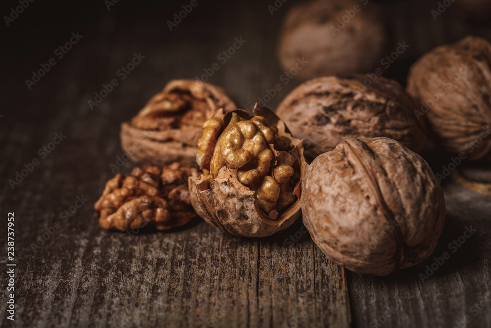 close up view of shelled and whole walnuts on wooden tabletop close up view of shelled and whole walnuts on wooden tabletop