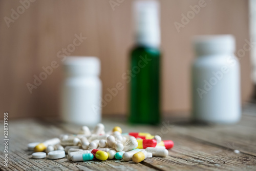 Selective focus on pill spread on wooden background. Global healthcare concept. Pharmaceutical industry.