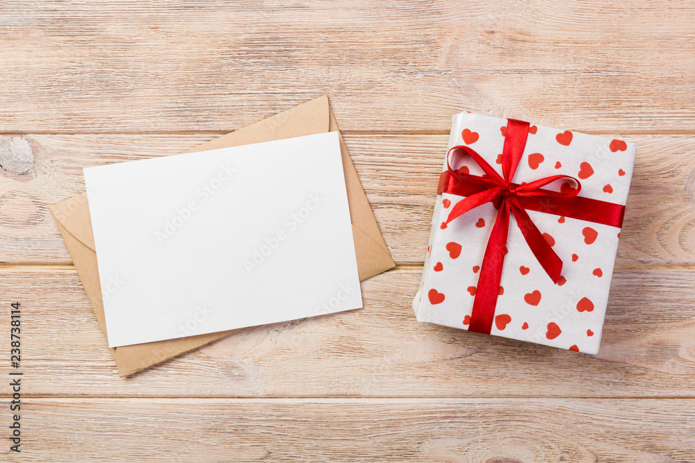 Envelope Mail with Red Heart and gift box over Orange Wooden Background. Valentine Day Card, Love or Wedding Greeting Concept Envelope Mail with Red Heart and gift box over Orange Wooden Background. Valentine Day Card, Love or Wedding Greeting Concept