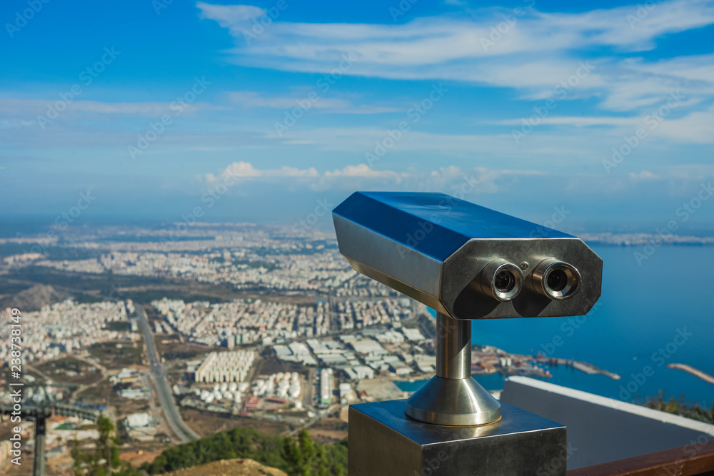 Closeup view of coin operated binocular viewer for looking in details at beautiful summer cityscape landscape. Antalya, Turkey. Happy summer holidays and sightseeing concept. Horizontal photography. Closeup view of coin operated binocular viewer for looking in details at beautiful summer cityscape landscape. Antalya, Turkey. Happy summer holidays and sightseeing concept. Horizontal photography.