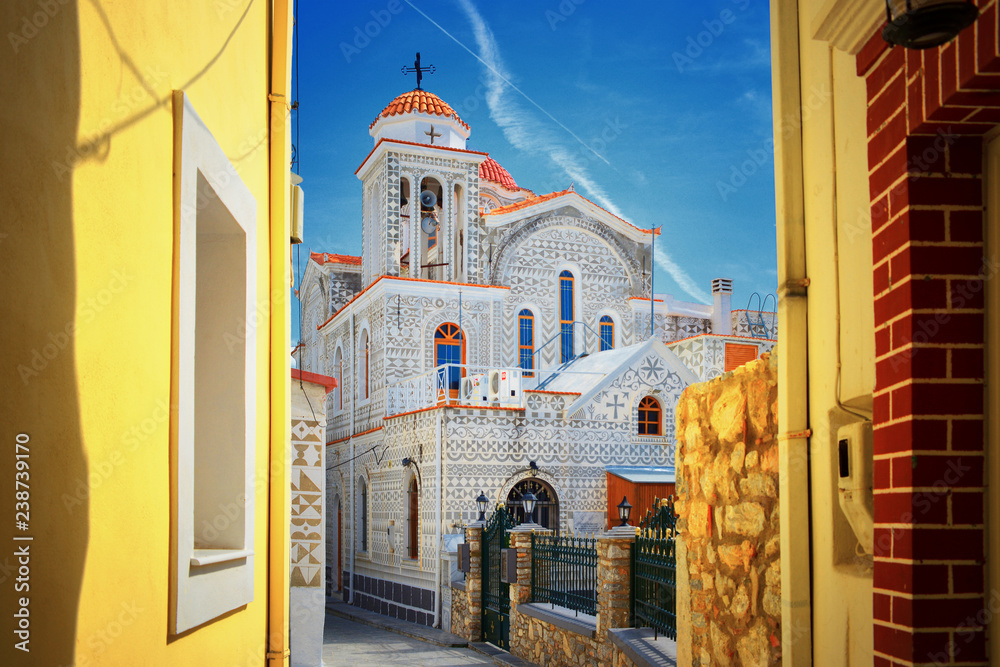 Mediterranean Greek Island Chios: Beautiful traditional ornamented church Pyrgi town with yellow colored walls of greek house buildings