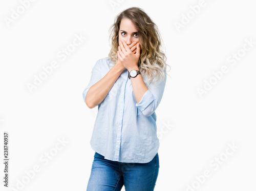 Beautiful young blonde business woman over isolated background shocked covering mouth with hands for mistake. Secret concept. © Krakenimages.com