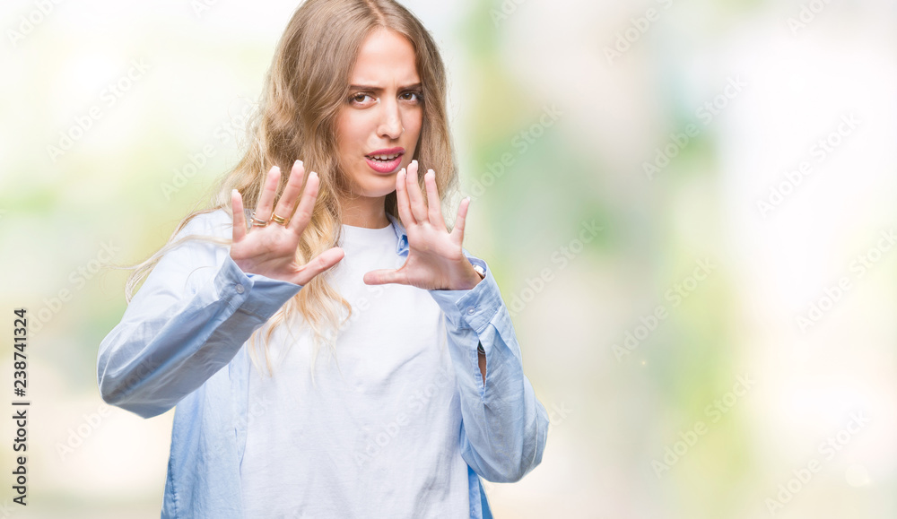 Beautiful young blonde woman over isolated background afraid and terrified with fear expression stop gesture with hands, shouting in shock. Panic concept. Beautiful young blonde woman over isolated background afraid and terrified with fear expression stop gesture with hands, shouting in shock. Panic concept.