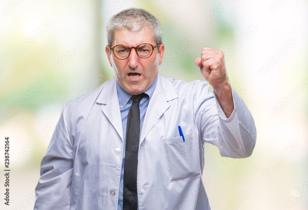 Handsome senior doctor, scientist professional man wearing white coat over isolated background angry and mad raising fist frustrated and furious while shouting with anger. Rage and aggressive concept. Handsome senior doctor, scientist professional man wearing white coat over isolated background angry and mad raising fist frustrated and furious while shouting with anger. Rage and aggressive concept.