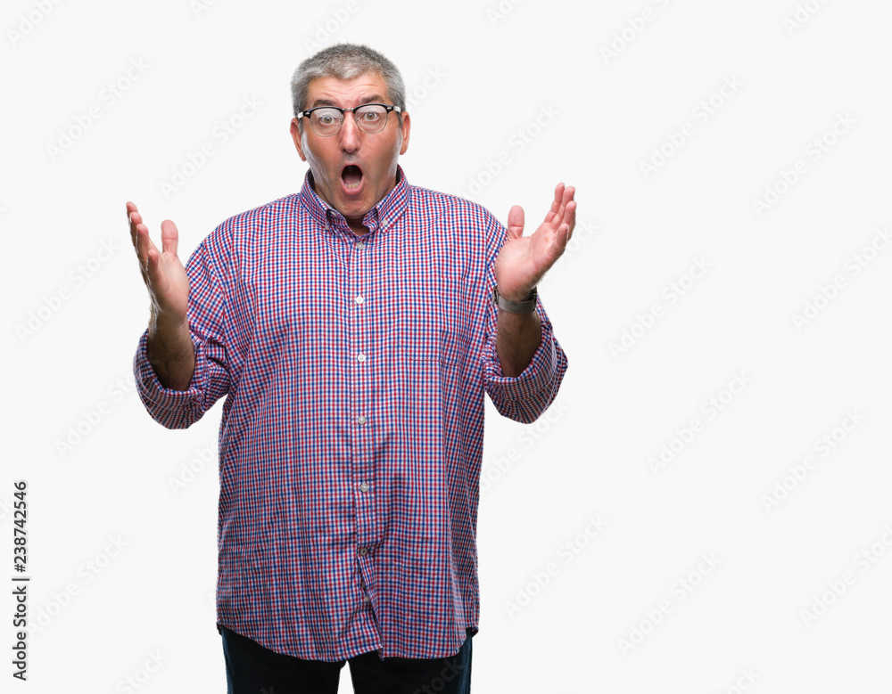 Handsome senior man wearing glasses over isolated background smiling and looking at the camera pointing with two hands and fingers to the side. Handsome senior man wearing glasses over isolated background smiling and looking at the camera pointing with two hands and fingers to the side.