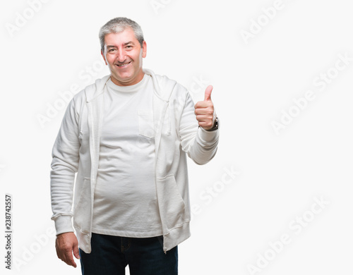 Handsome senior man wearing sport clothes over isolated background doing happy thumbs up gesture with hand. Approving expression looking at the camera with showing success.