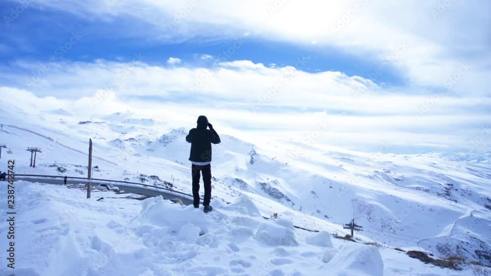 One man stands with open arms watching the mountains with snow One man stands with open arms watching the mountains with snow