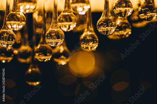 Crystal lighting electric chandelier, glass balls, a sphere emit a warm orange light.