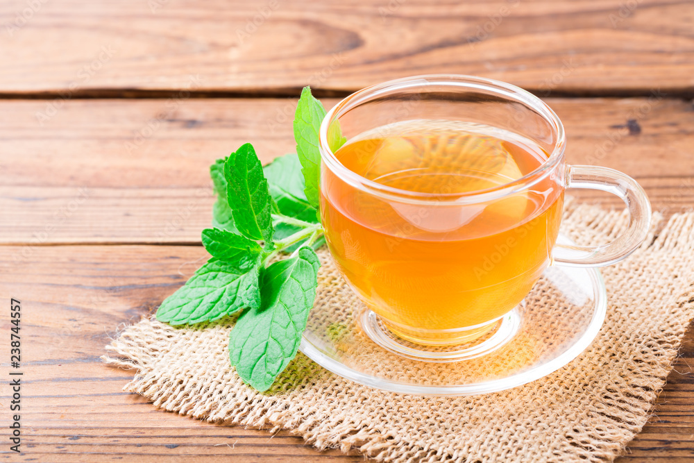 Fresh mint tea with leaves on wooden table Fresh mint tea with leaves on wooden table