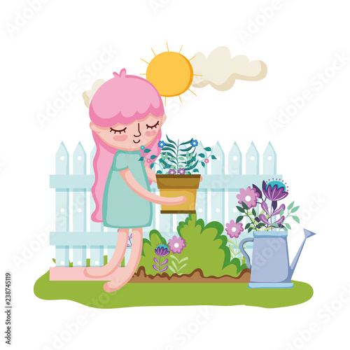 little girl lifting houseplant with fence and sprinkler