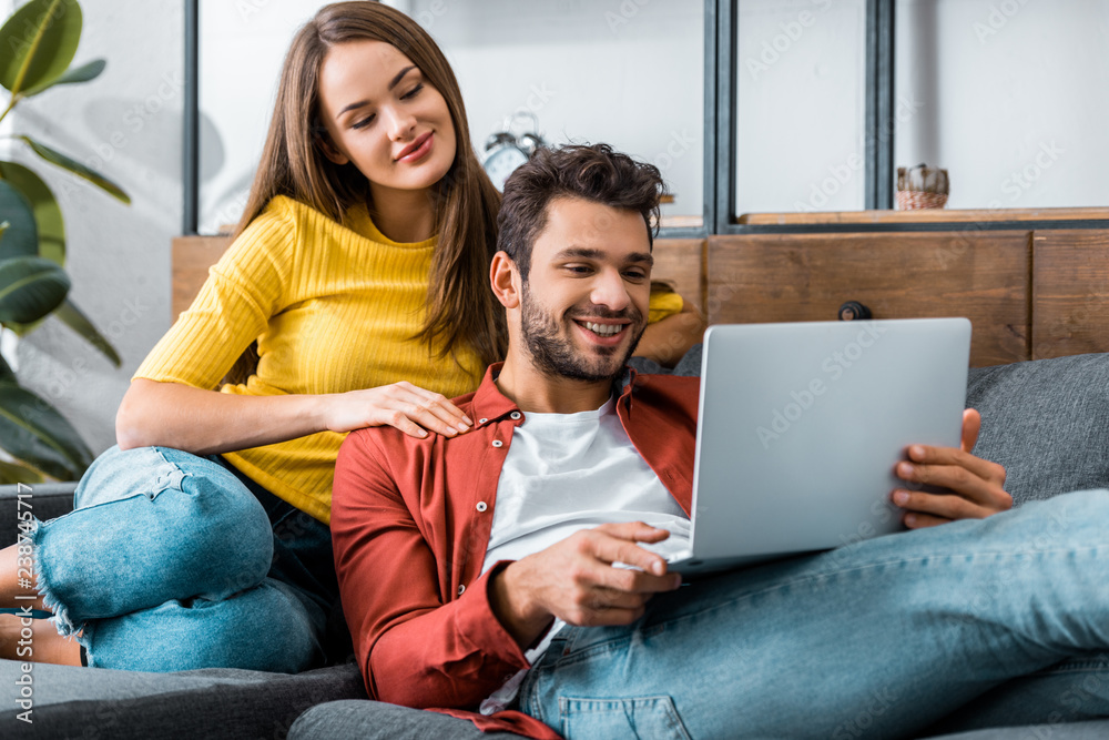young couple looking at laptop in living room