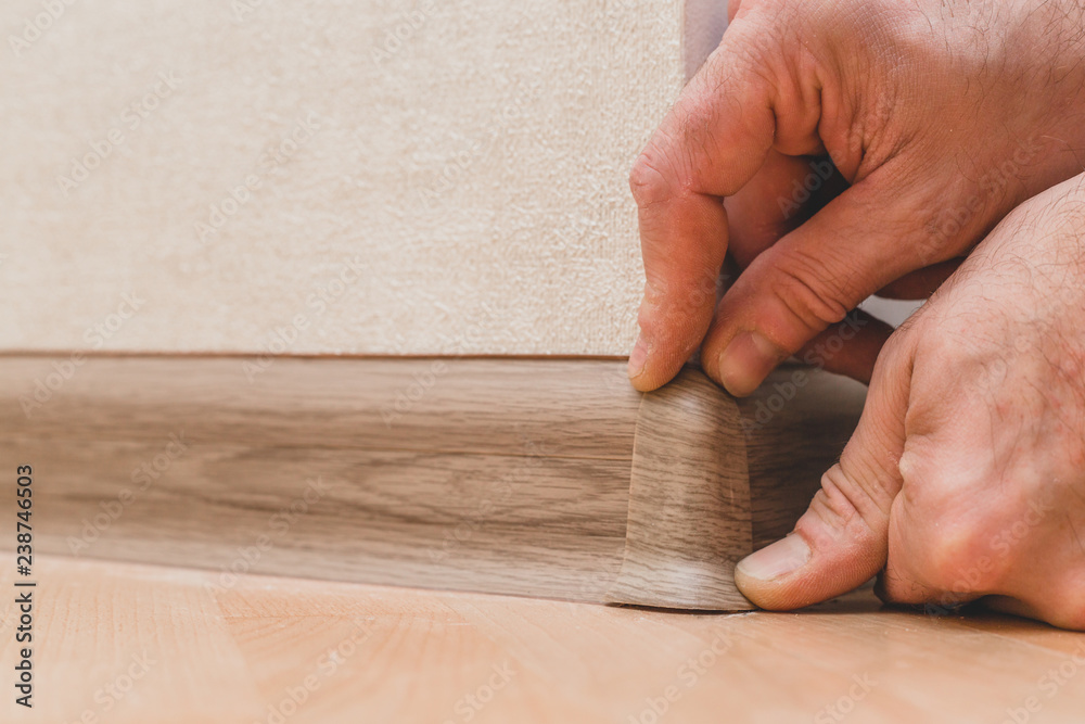 Technology of installation and installation of plastic floor plinth - Master sets the outer corner on the baseboard Technology of installation and installation of plastic floor plinth - Master sets the outer corner on the baseboard