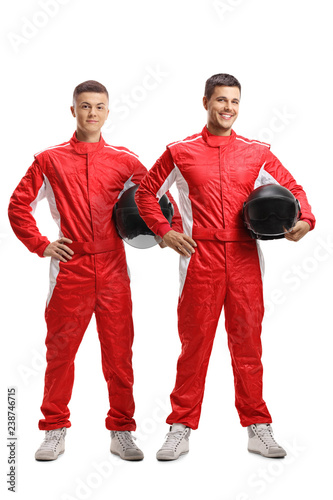 Two young racers standing and holding helmets