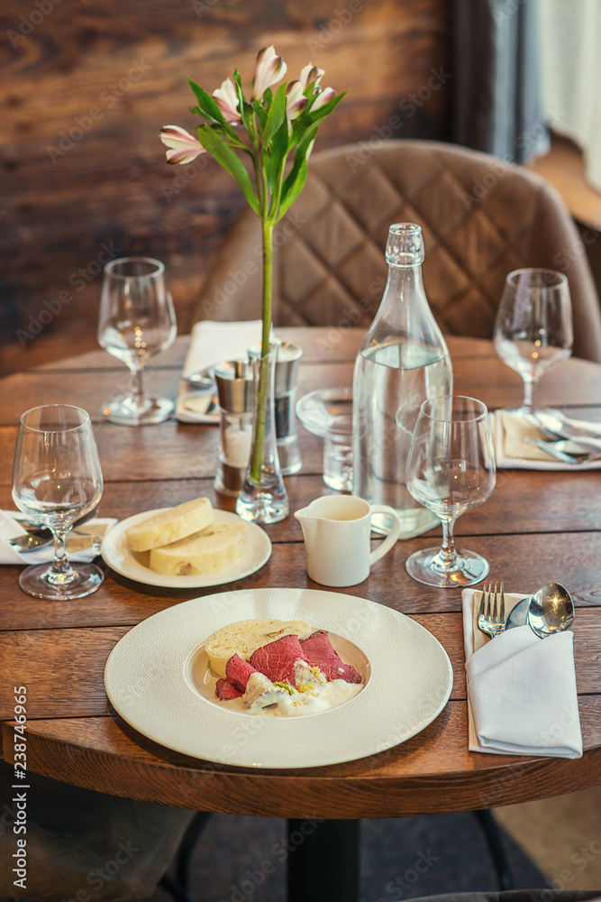 delicious beef with horseradish sauce and dumplings served on white plate, product photography for gastronomy