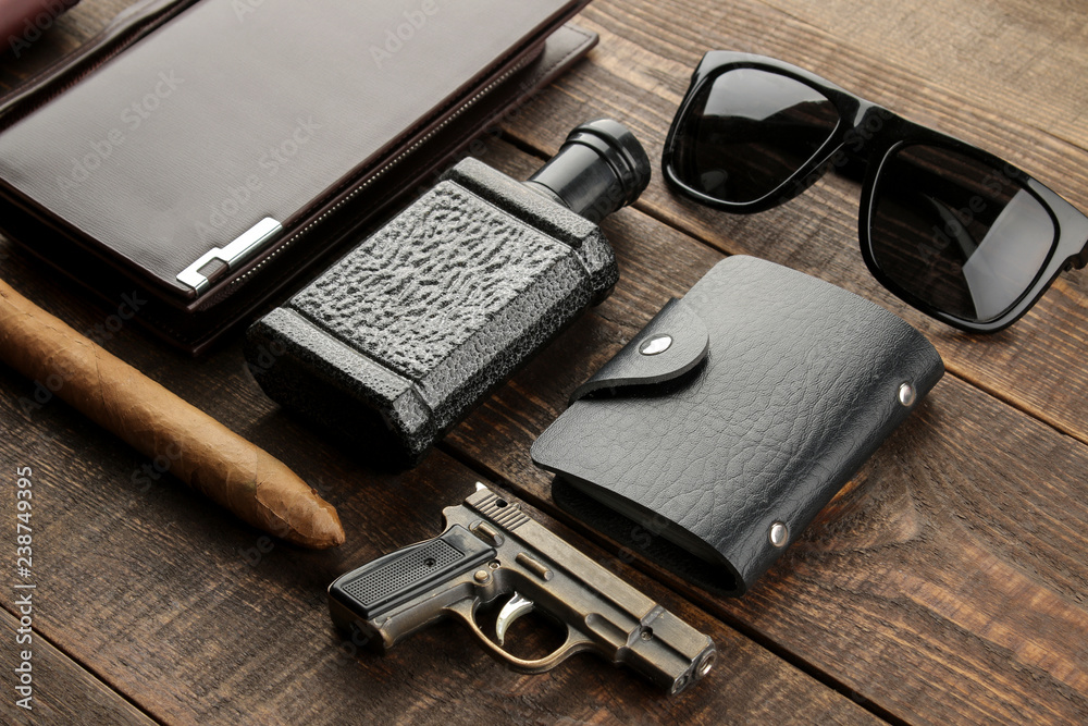 Men's Accessories. men's style. Cigar, perfume, wallet, glasses, business card holder, headphones on a brown wooden background. Men's Accessories. men's style. Cigar, perfume, wallet, glasses, business card holder, headphones on a brown wooden background.