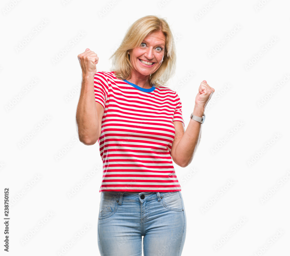 Middle age blonde woman over isolated background very happy and excited doing winner gesture with arms raised, smiling and screaming for success. Celebration concept. Middle age blonde woman over isolated background very happy and excited doing winner gesture with arms raised, smiling and screaming for success. Celebration concept.