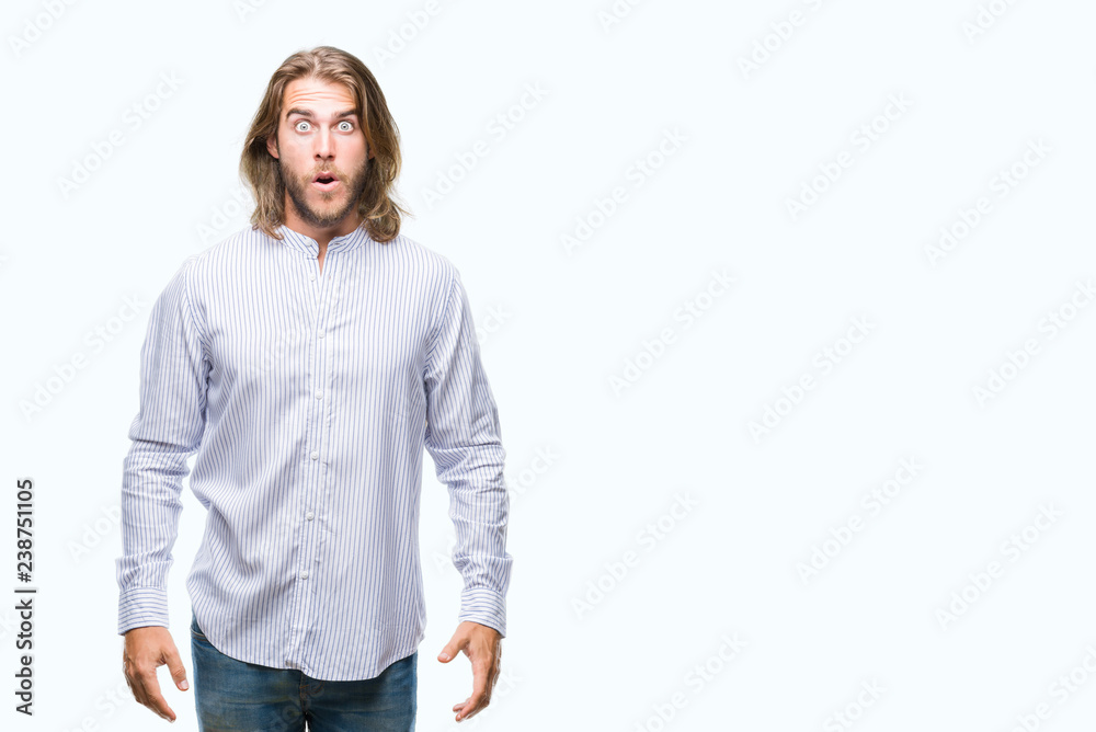 Fototapeta premium Young handsome man with long hair over isolated background afraid and shocked with surprise expression, fear and excited face.
