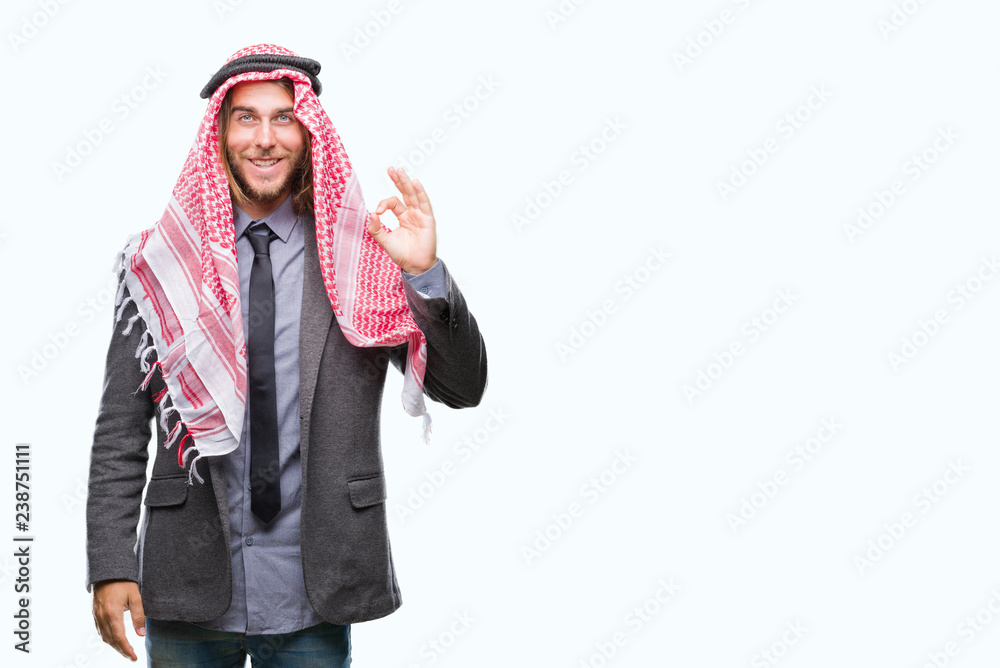 Young handsome arabian man with long hair wearing keffiyeh over isolated background smiling positive doing ok sign with hand and fingers. Successful expression. Young handsome arabian man with long hair wearing keffiyeh over isolated background smiling positive doing ok sign with hand and fingers. Successful expression.