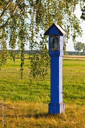 Old blue chapel on the green field