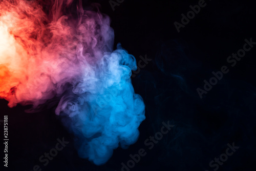 A cloud of smoke evaporating in soft waves with a rainbow effect: red, orange, yellow, green, cyan, magenta, colors on a dark background.