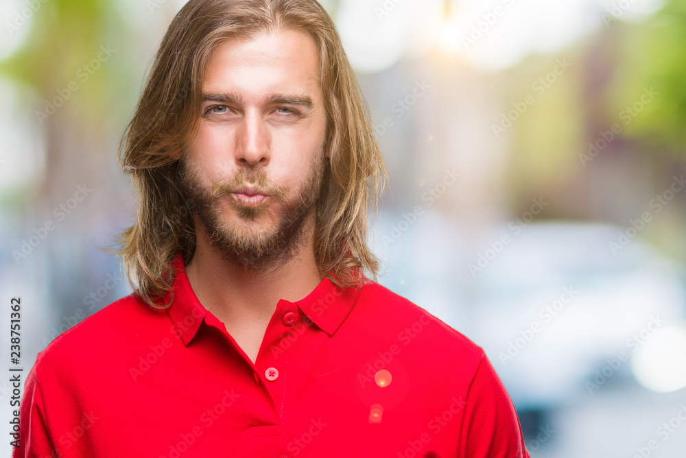 Young handsome man with long hair over isolated background puffing cheeks with funny face. Mouth inflated with air, crazy expression. Young handsome man with long hair over isolated background puffing cheeks with funny face. Mouth inflated with air, crazy expression.