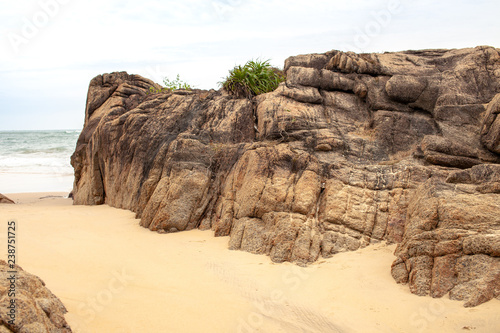 Boulders on the sandy beach by the sea