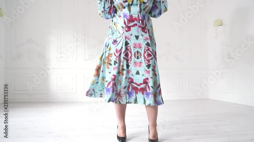 Plump model in a beautiful dress posing in bright studio. Plump woman posing in beautiful outfit.