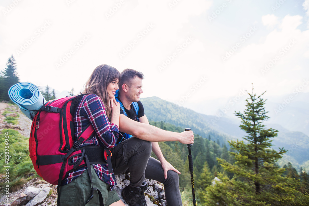 Young couple of hikers enjoying a hiking trip