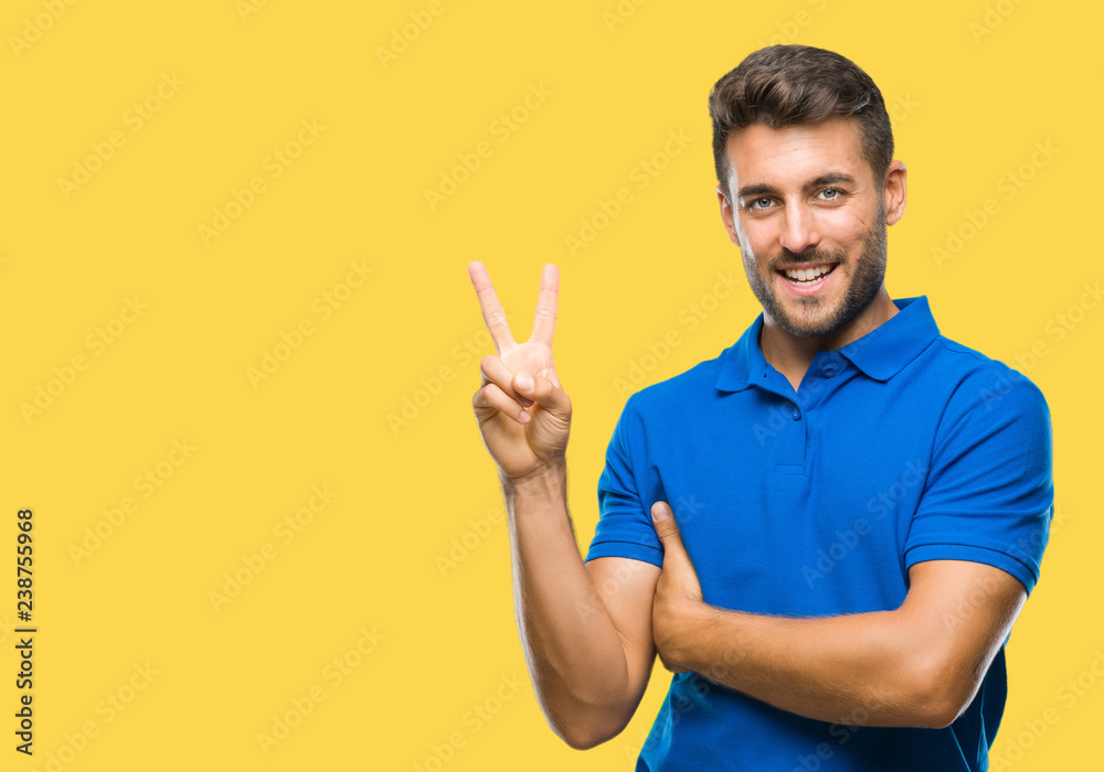 Young handsome man over isolated background smiling with happy face winking at the camera doing victory sign. Number two. Young handsome man over isolated background smiling with happy face winking at the camera doing victory sign. Number two.