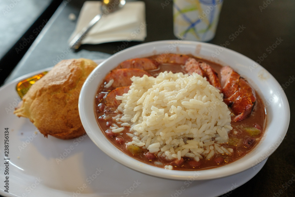 A bowl of beans and rice with sausage and a cornbread muffin on the side A bowl of beans and rice with sausage and a cornbread muffin on the side
