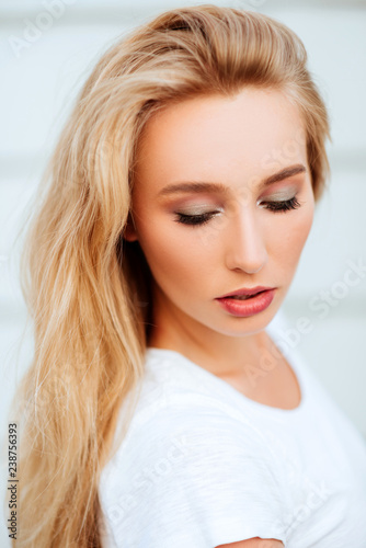 Portrait of blond young woman posing outdoors. Lifestyle