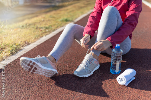 Girl tying running shoes. Young fitness woman runner athlete. Sport active lifestyle concept.
