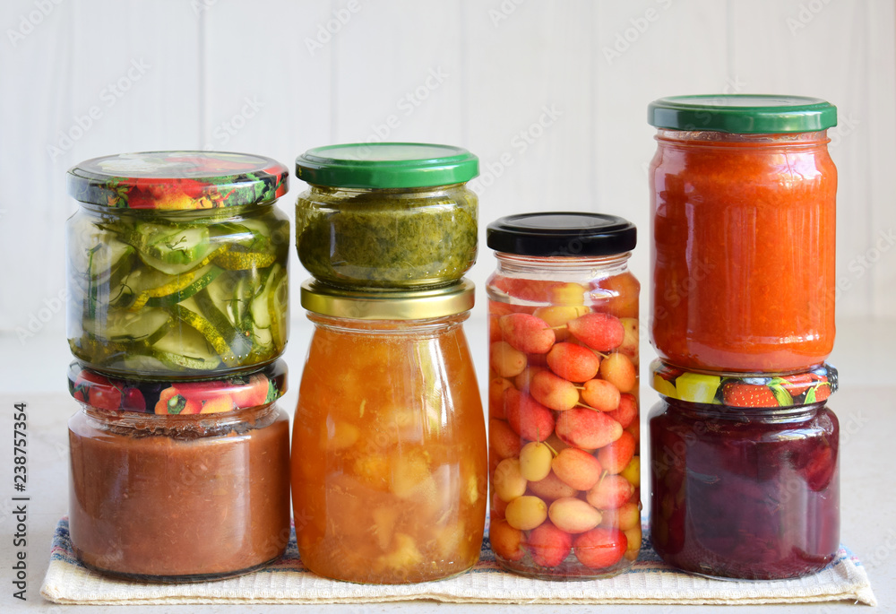 Variety of preserved food in glass jars - pickles, jam, marmalade, sauces, ketchup. Preserving vegetables and fruits. Fermented food. Autumn canning. Conservation of harvest Variety of preserved food in glass jars - pickles, jam, marmalade, sauces, ketchup. Preserving vegetables and fruits. Fermented food. Autumn canning. Conservation of harvest