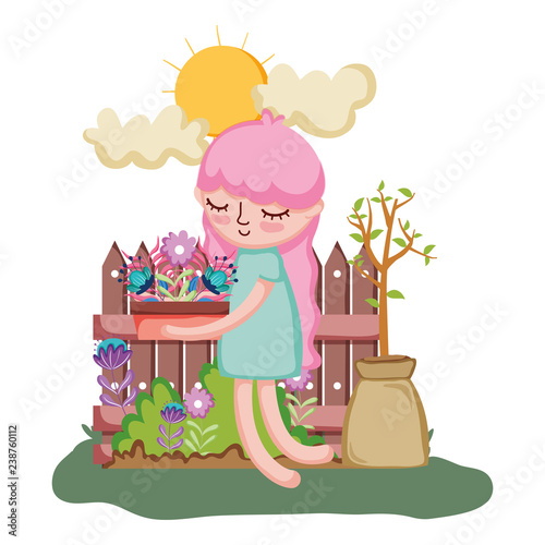 girl lifting houseplant with fence in the garden