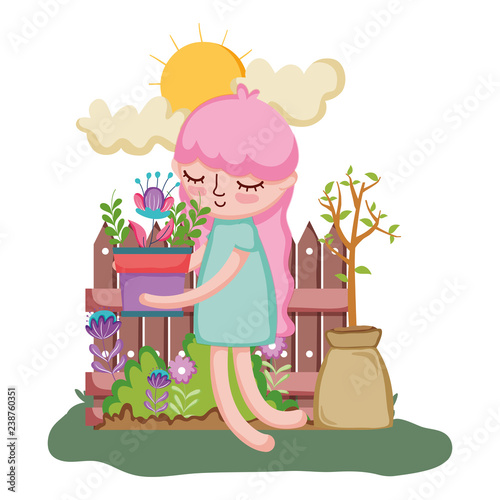 girl lifting houseplant with fence in the garden