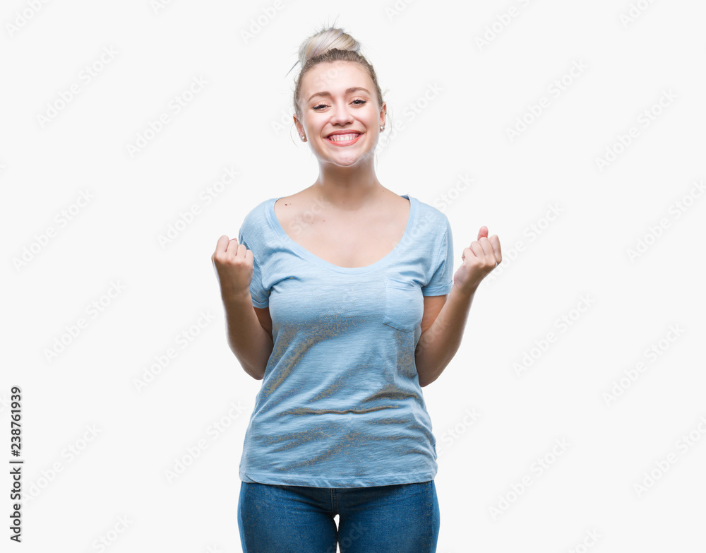 Young blonde woman over isolated background celebrating surprised and amazed for success with arms raised and open eyes. Winner concept. Young blonde woman over isolated background celebrating surprised and amazed for success with arms raised and open eyes. Winner concept.