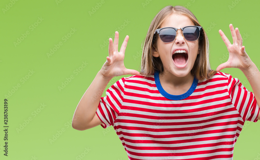 Young beautiful girl wearing sunglasses over isolated background crazy and mad shouting and yelling with aggressive expression and arms raised. Frustration concept. Young beautiful girl wearing sunglasses over isolated background crazy and mad shouting and yelling with aggressive expression and arms raised. Frustration concept.