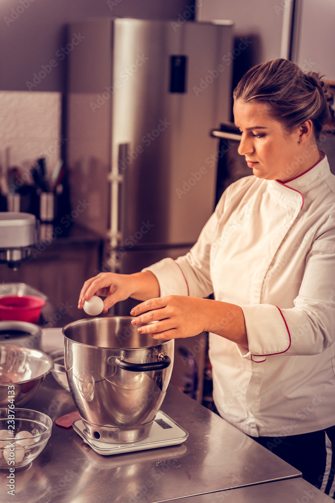 Nice skilled female chef breaking the egg Nice skilled female chef breaking the egg