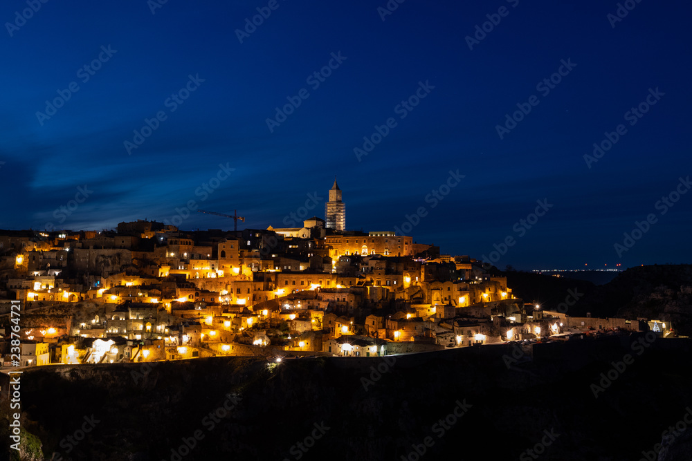 Panorama of Matera and Gravina by night seen from the archaeological park of the Murge Materane, Basilicata, Italy